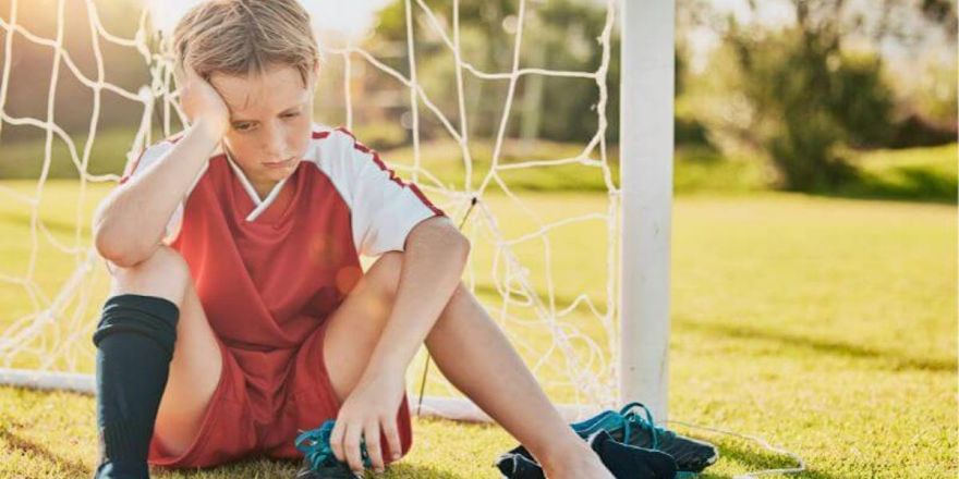 niño nervioso y triste antes del partido de futbol