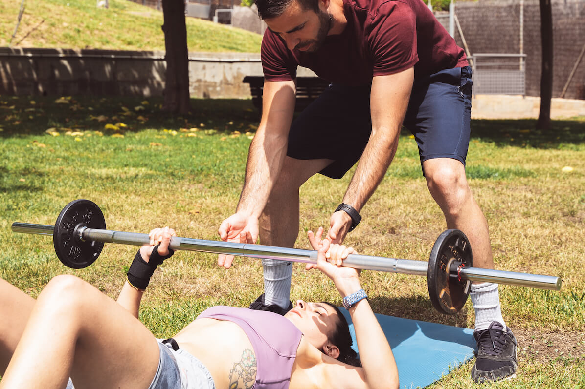 mujer ejercitándose a domicilio con entrenador personal