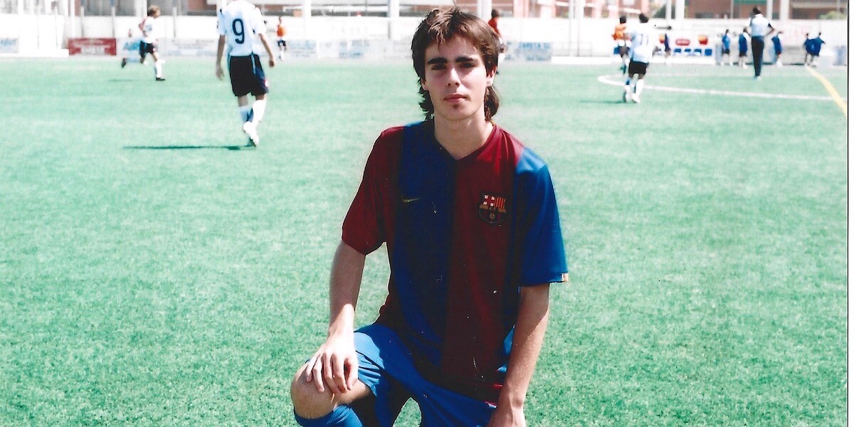 deportista jóven del F.C.Barcelona arrodillado en el césped